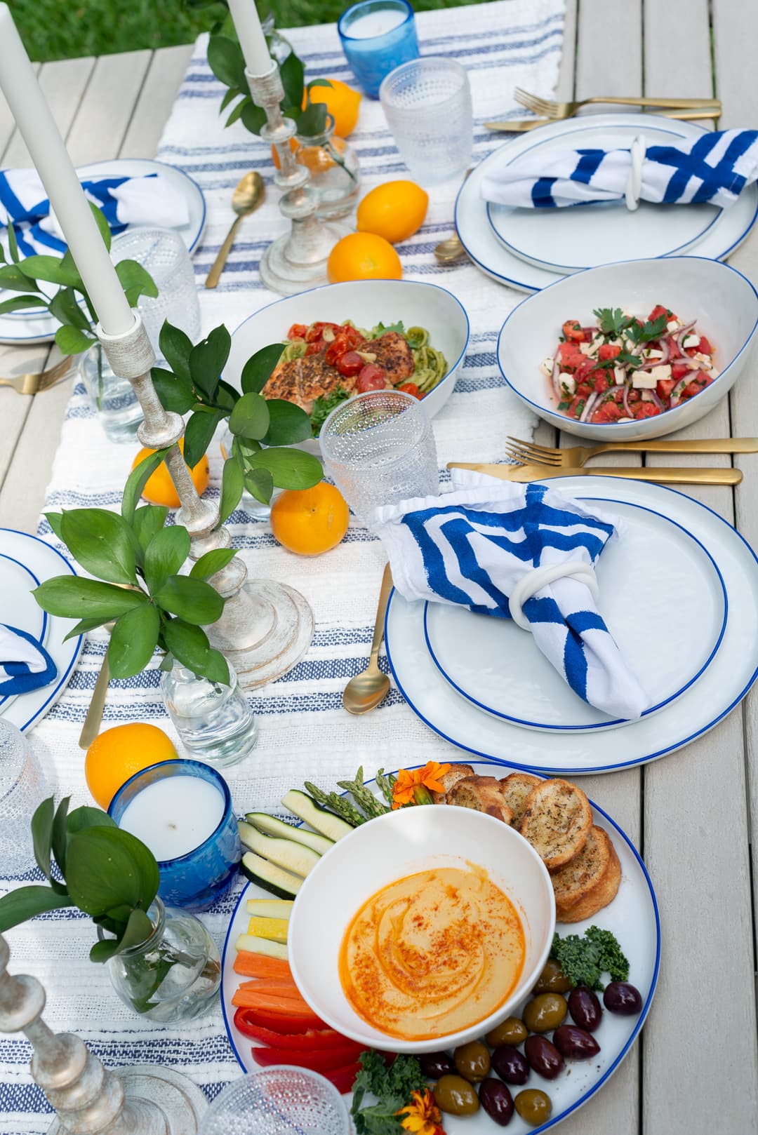 An al fresco Mediterranean table with blue and white plates and fresh lemons, set by a private chef in Fort Lauderdale