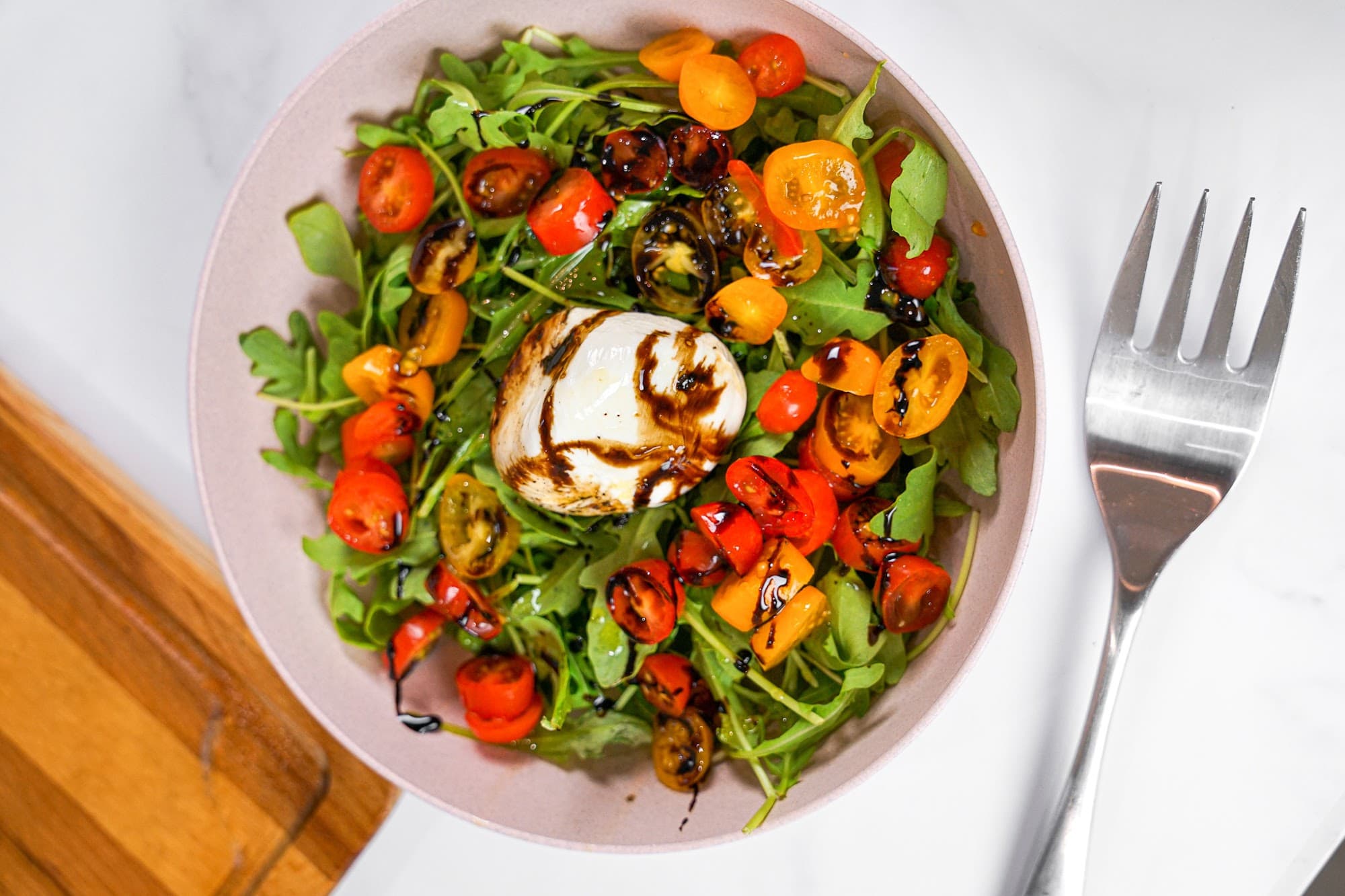 A colorful heirloom tomato caprese salad with fresh basil, plated by a private chef in Wynwood