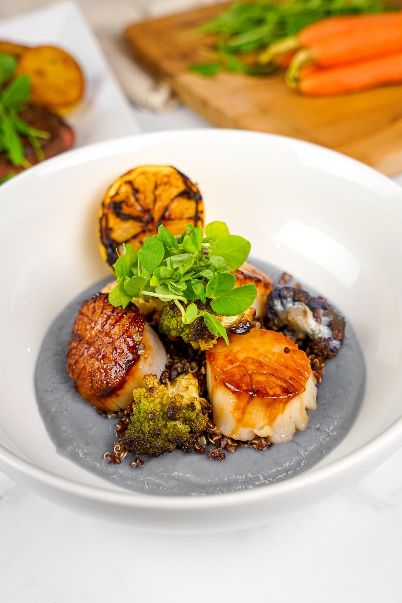 Seared scallops on a smoked purée with charred lemon, plated by a private chef in Miami