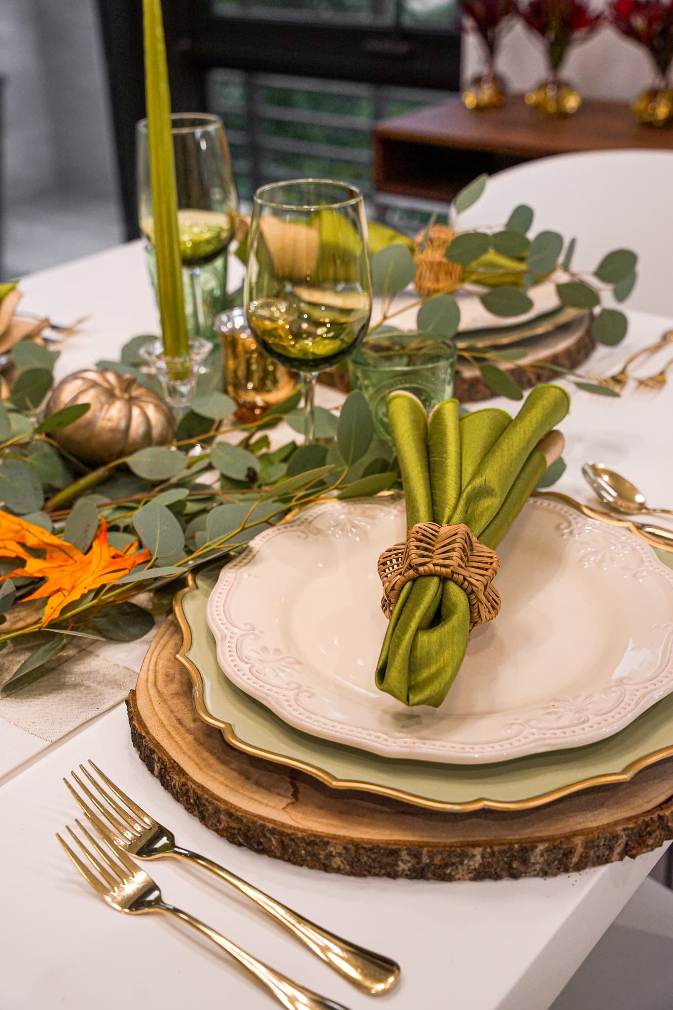 An elegant green-toned table setting with gold flatware, arranged by a private chef for a family dinner in Aventura