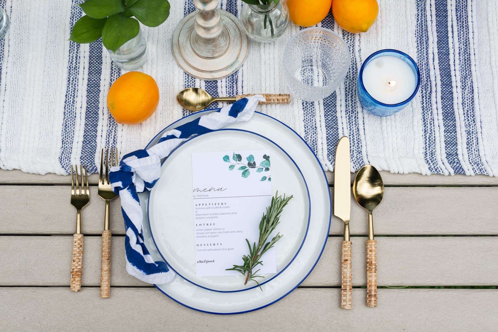 A Mediterranean place setting with a blue striped runner and lemons set by a private chef on Key Biscayne