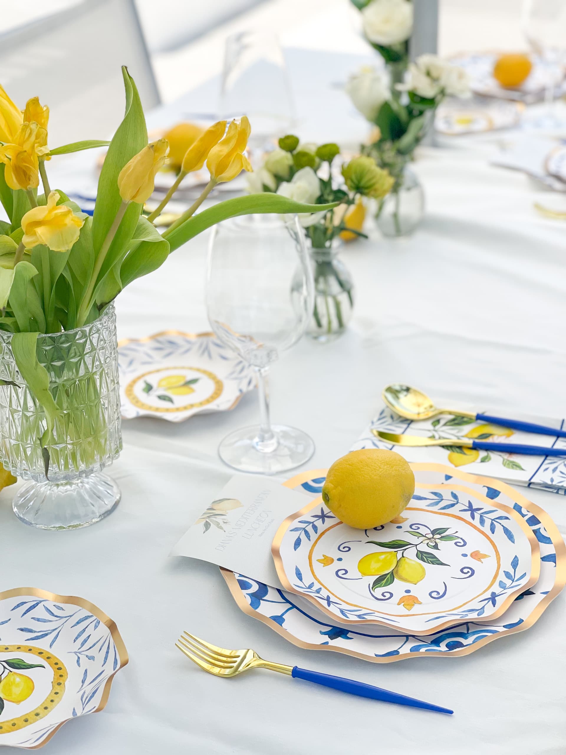 A fresh table with yellow tulips, lemons, and gold accents set for a family private chef dinner in Pinecrest