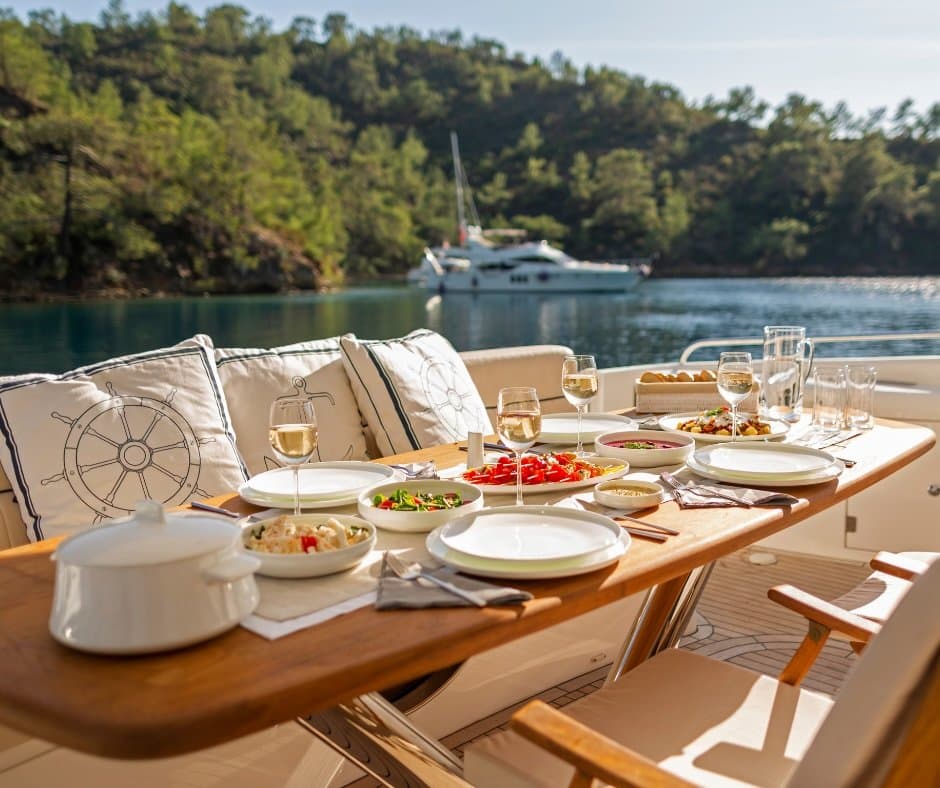 A yacht lunch table set at anchor in a calm bay