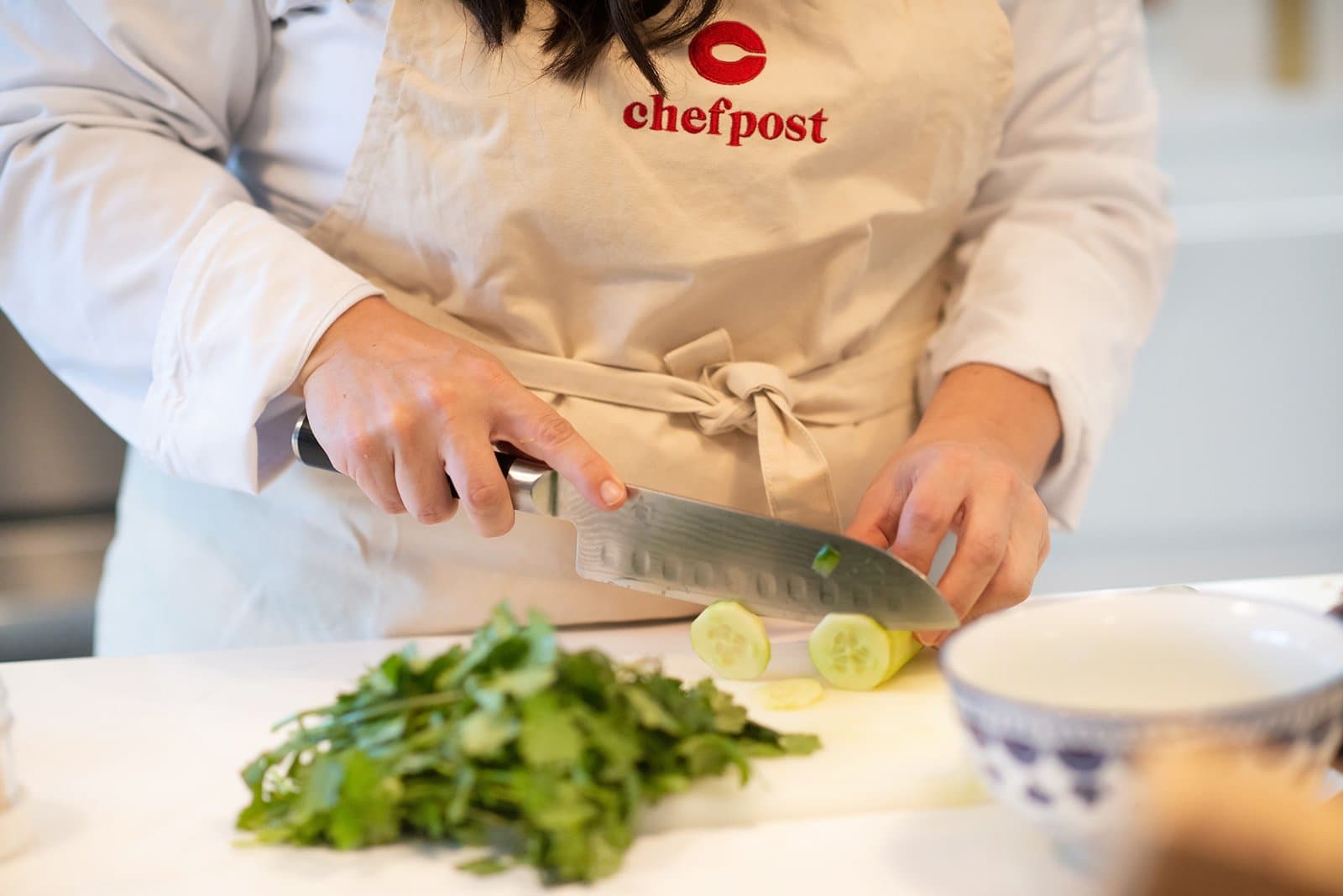 A Chefpost personal chef chopping fresh herbs in a client's home kitchen