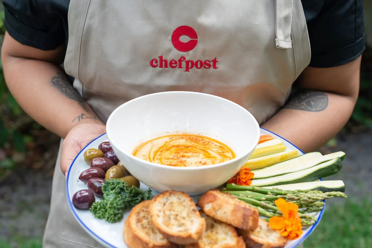 A chef presenting a shared platter for a celebration at home