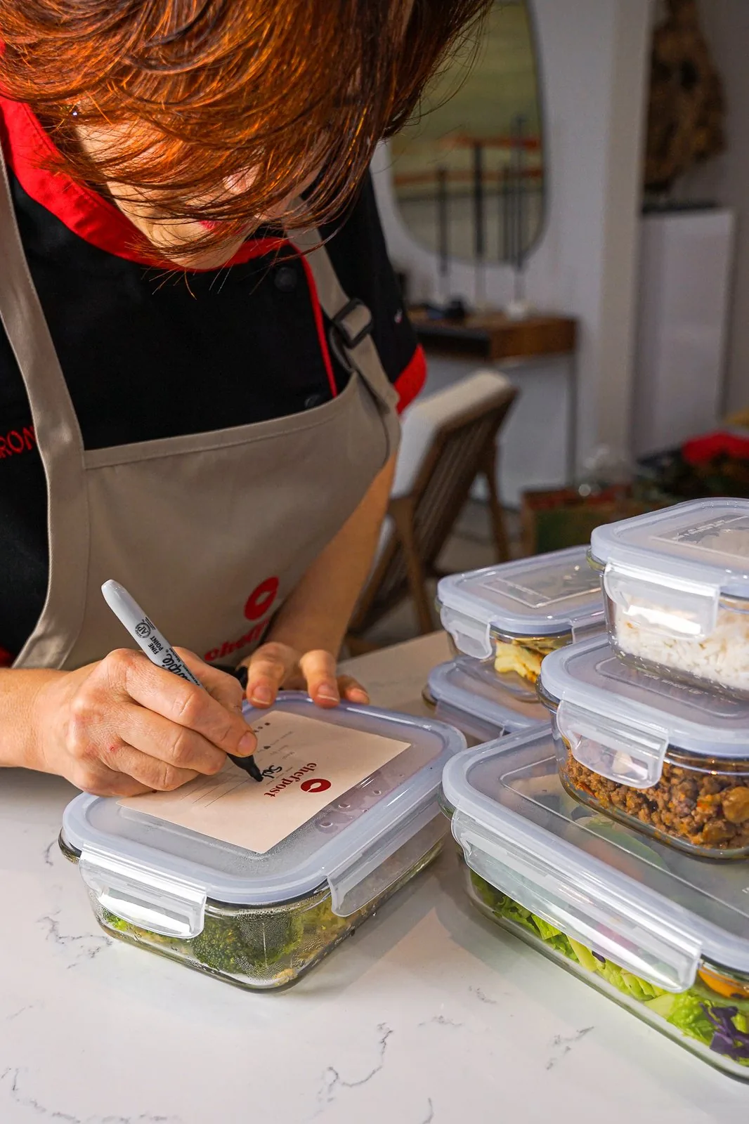 A Chefpost chef plating portioned family meals in a Pinecrest kitchen