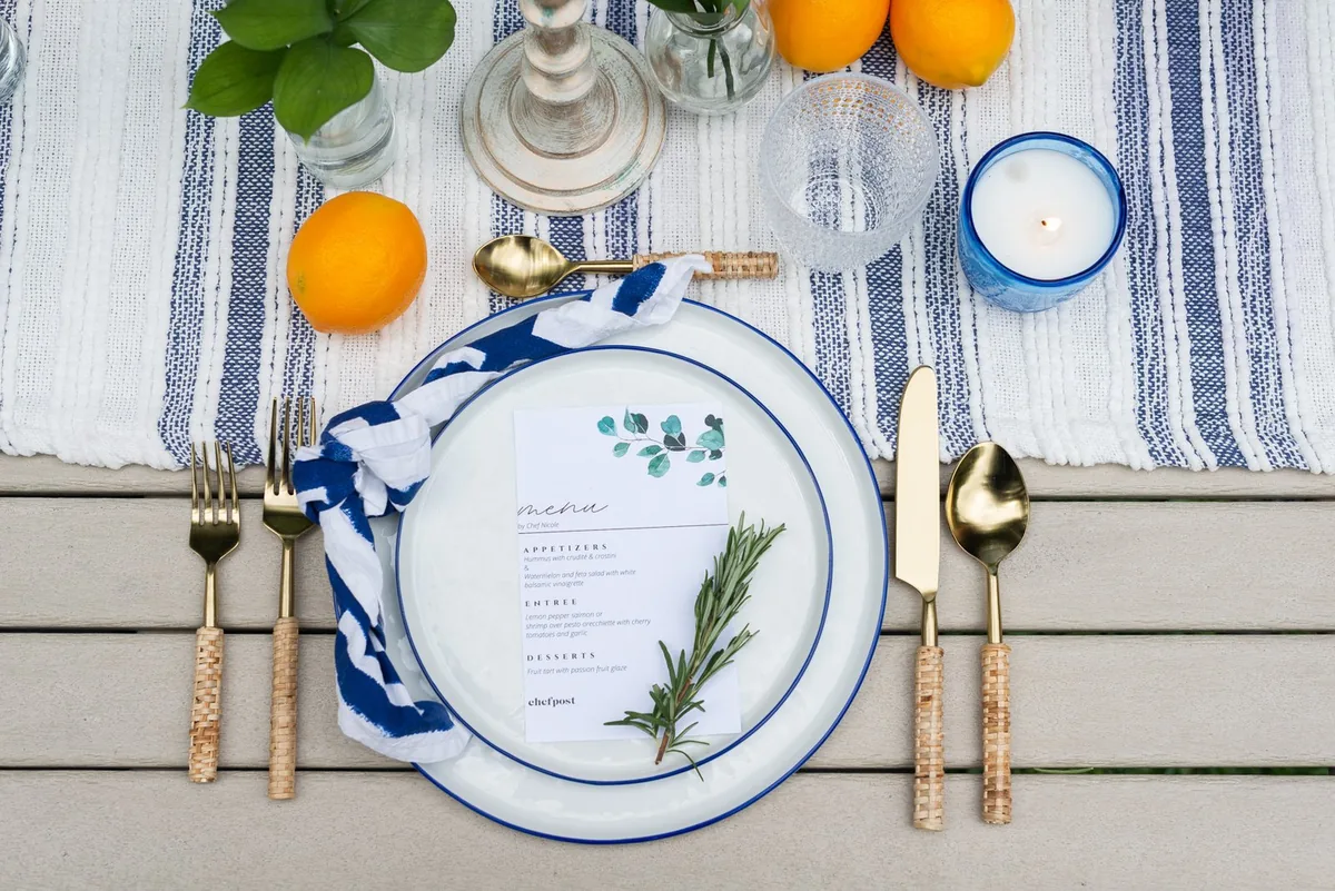 A Mediterranean place setting with a blue striped runner and lemons set by a private chef on Key Biscayne