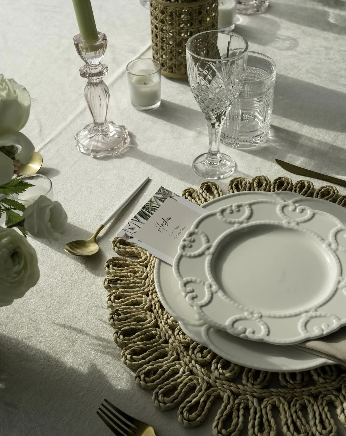 An elegant neutral place setting with a fringed placemat and gold cutlery, set by a private chef in Bal Harbour