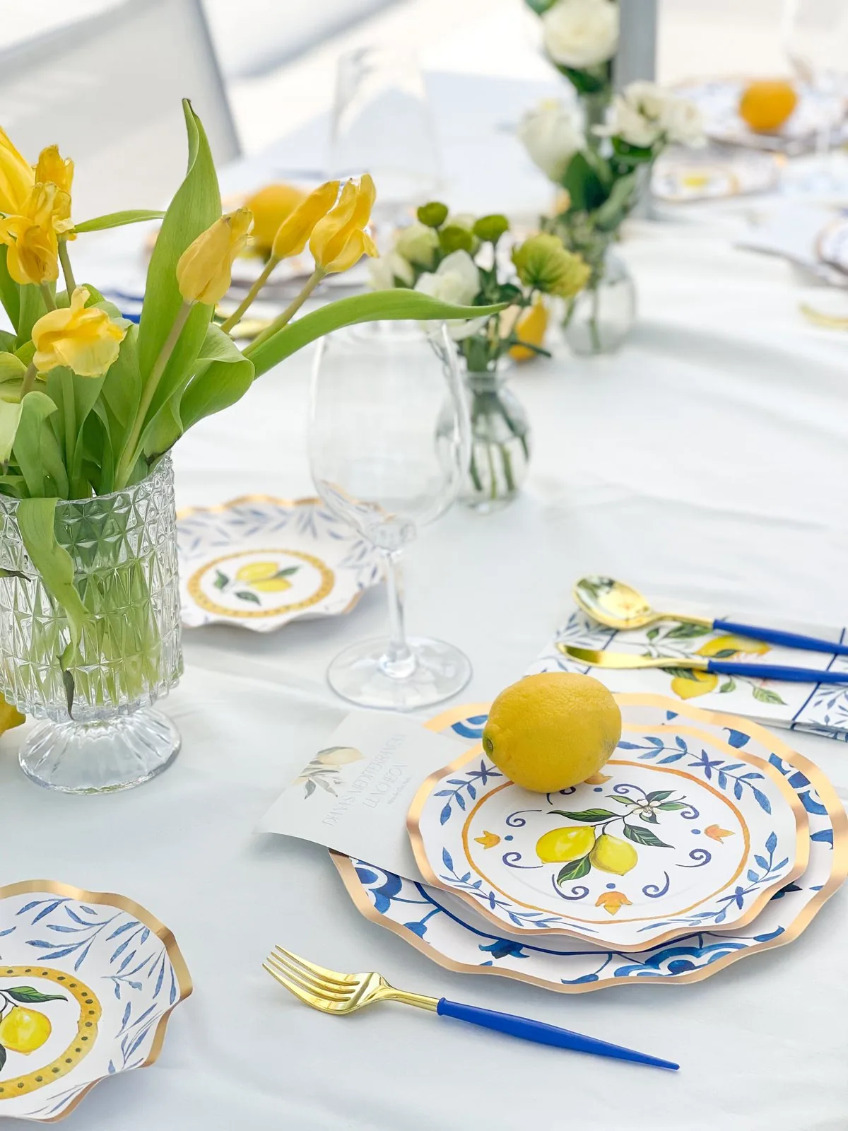 A fresh table with yellow tulips, lemons, and gold accents set for a family private chef dinner in Pinecrest